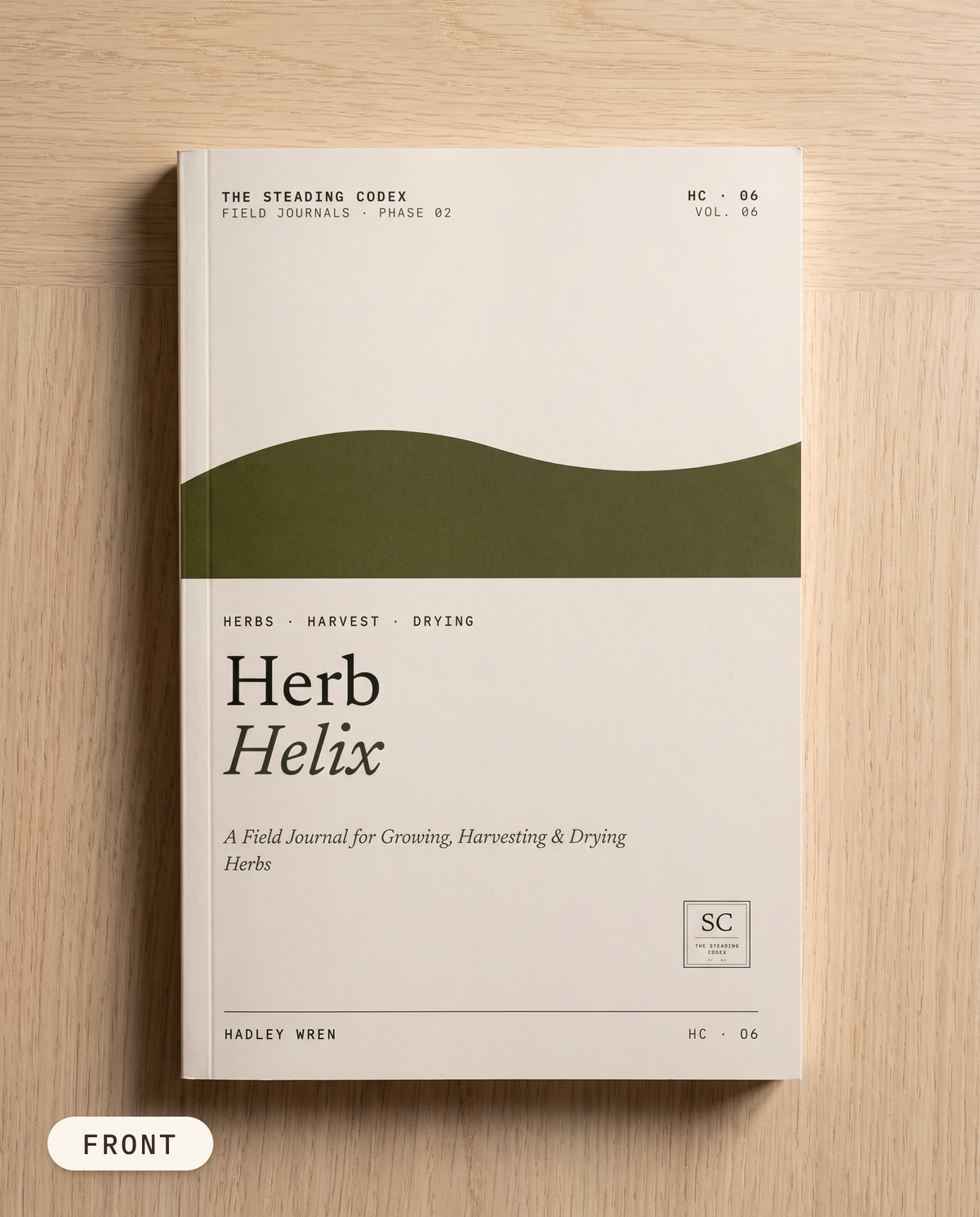 Herb Helix herb growing journal — front cover on an oak table