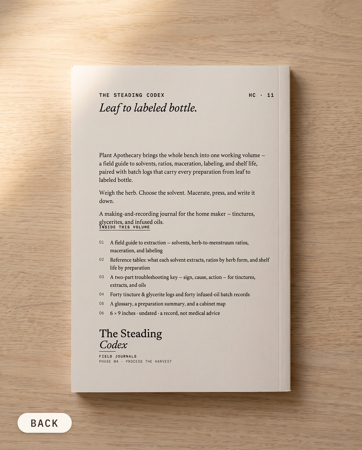 Plant Apothecary herbal preparation journal — back cover on an oak table